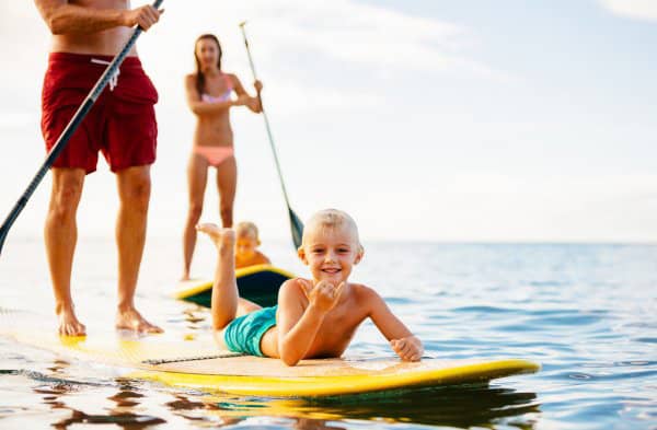 Two Adults on on a stand up paddleboard, rented from San Diego Surf School.