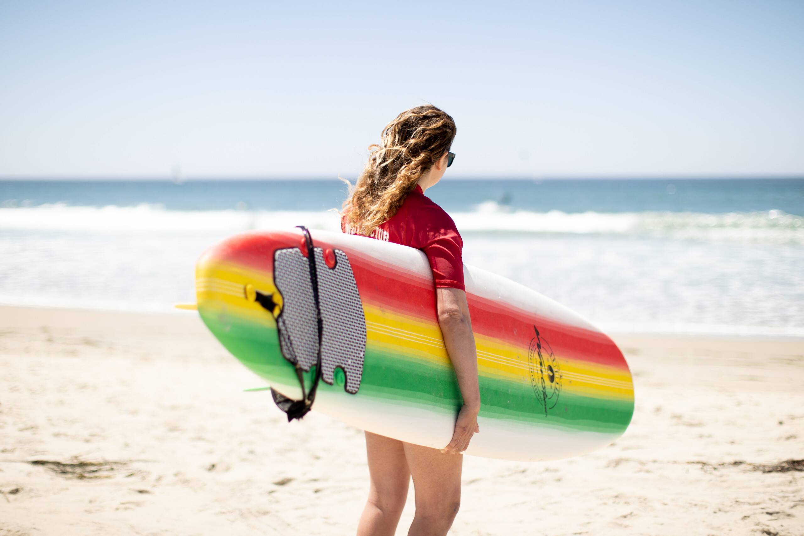 surfing techniques woman walking surfboard on the beach into the ocean