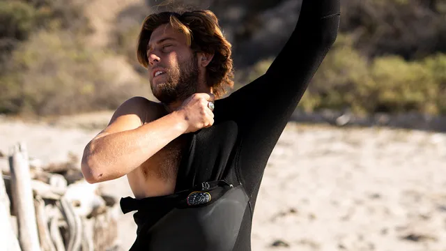 young man putting on a wetsuit