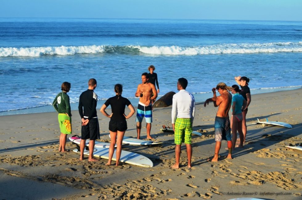 group of people standing on the beach with different things to wear for surfing