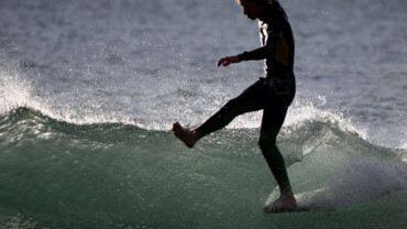 person falling off surfboard on a barreling wave