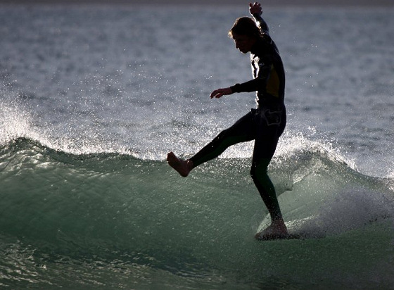 person falling off surfboard on a barreling wave