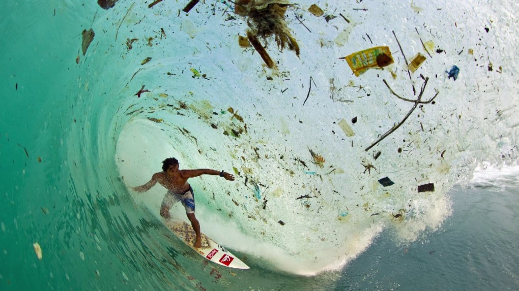 surfer with heavy debris in water, eco friendly surfing