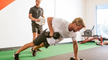 man practicing surf exercises with weights