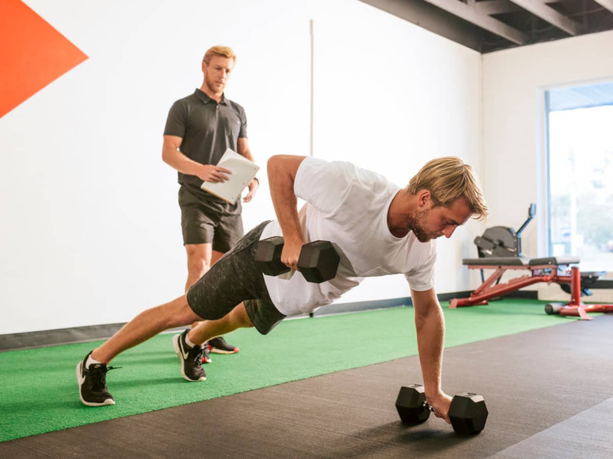man practicing surf exercises with weights