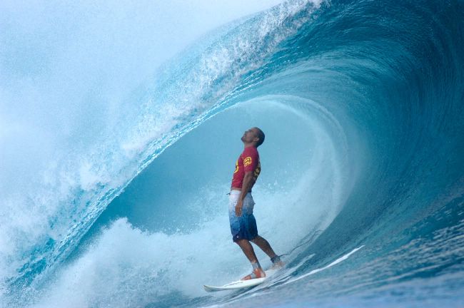 kelly slater standing in the barrel of a perfect wave